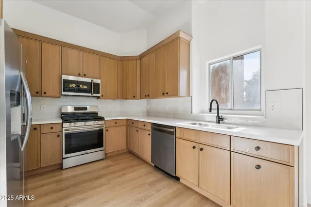 a kitchen with granite countertop a sink stainless steel appliances and cabinets