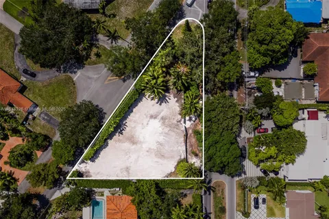 an aerial view of residential house with outdoor space and trees all around