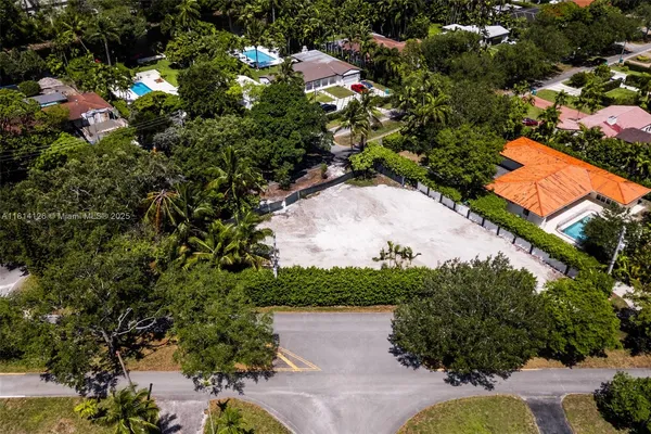 an aerial view of a house with a yard and lake view