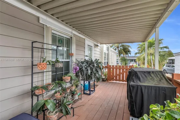 a view of a patio with table and chairs potted plants with wooden floor