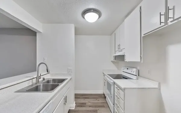 a kitchen with a refrigerator sink and cabinets