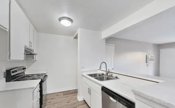a view of kitchen with stainless steel appliances granite countertop stove top oven and cabinets
