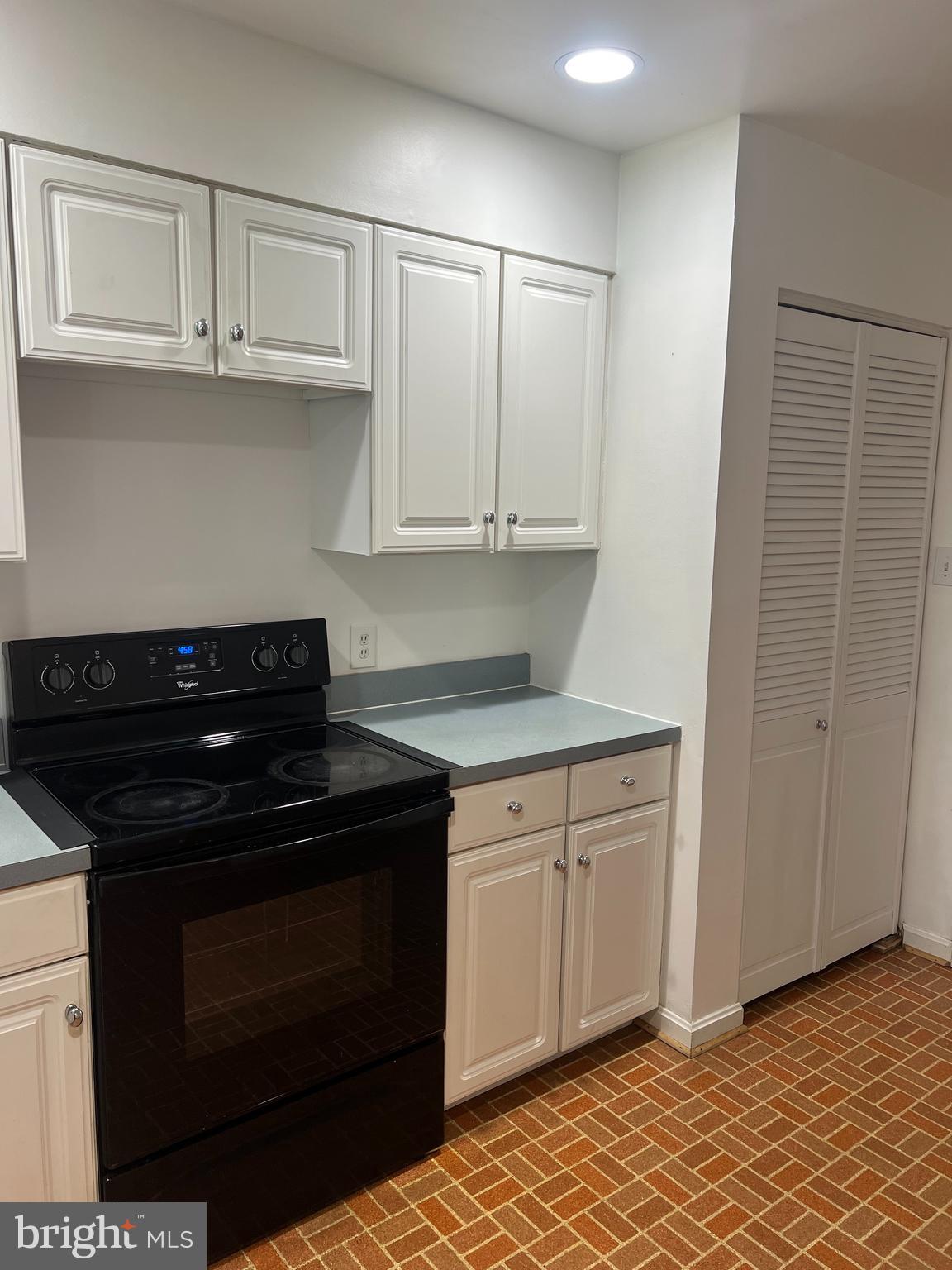 2040 Golf Course Drive Reston, VA 20191 - Photo 10 of 34 a kitchen with granite countertop white cabinets and black appliances