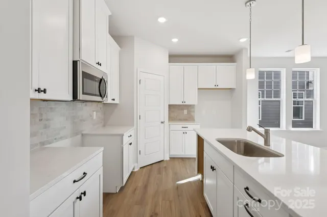 a kitchen with stainless steel appliances granite countertop a sink stove and microwave