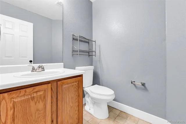 a bathroom with a granite countertop sink toilet and a mirror