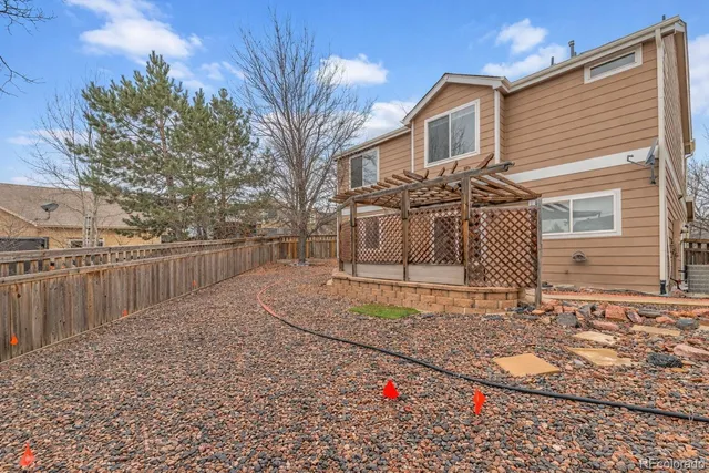 a view of a house with a small yard and wooden fence