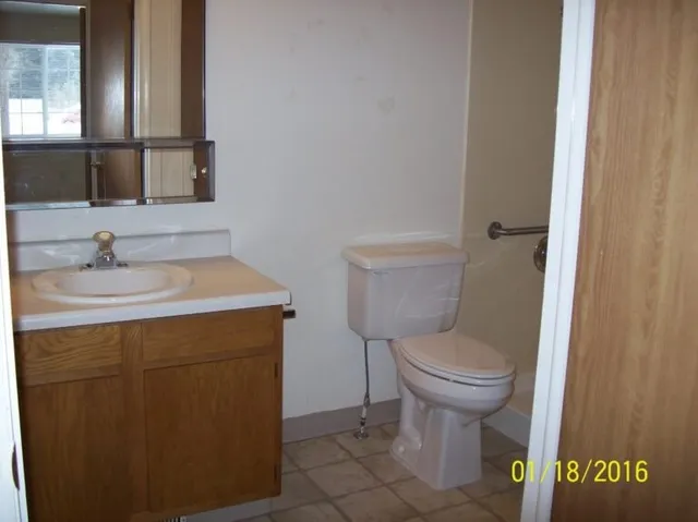 a bathroom with a sink toilet and a mirror