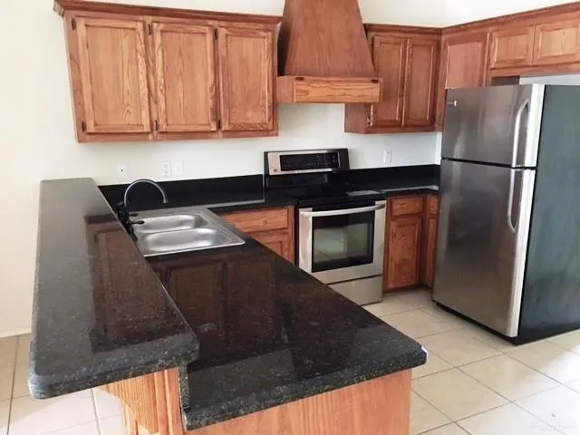 a kitchen with a refrigerator sink and cabinets