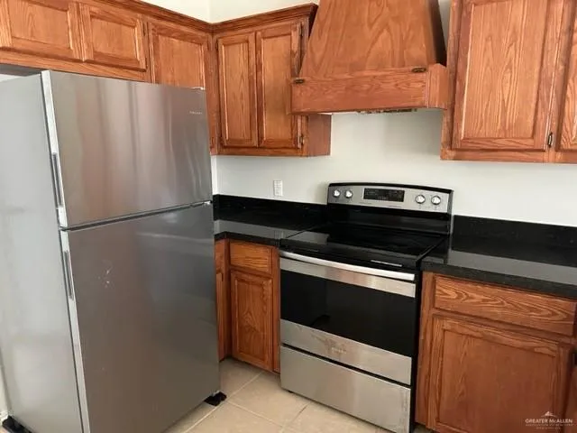 a kitchen with kitchen island granite countertop a cabinets and refrigerator