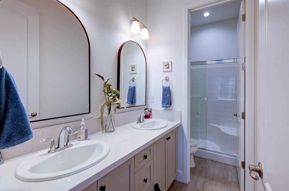 1048 Beaver Pond Loop Madera, CA 93636 - Photo 22 of 27 a bathroom with a double vanity sink and a mirror