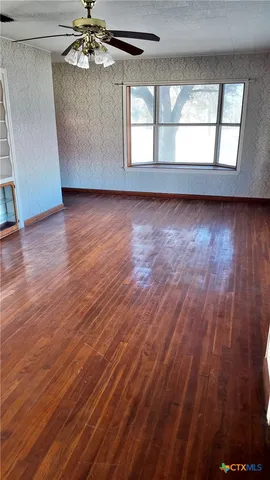 wooden floor in an empty room with a window