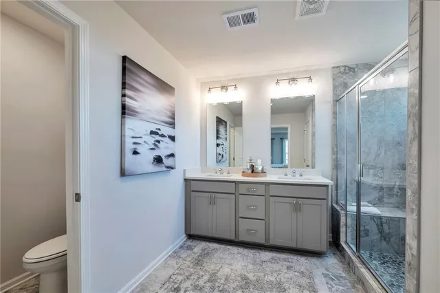 a spacious bathroom with a double vanity sink toilet and a shower