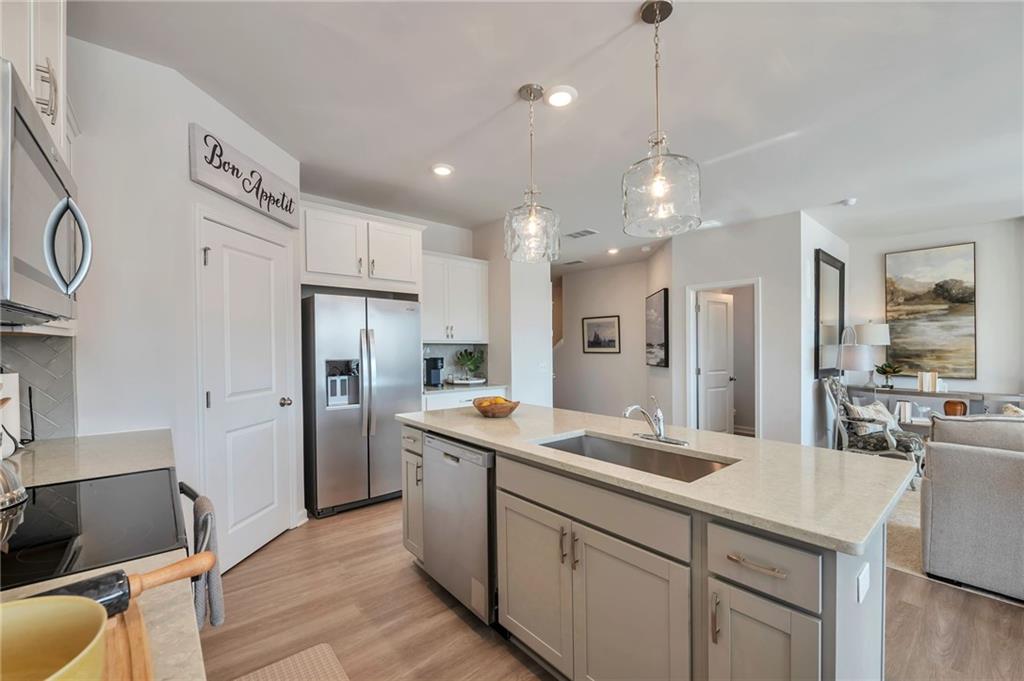 104 Windmill Court Calhoun, GA 30701 - Photo 4 of 23 a kitchen with kitchen island a sink appliances and cabinets