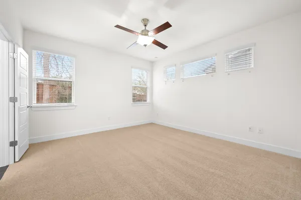 an empty room with closet and ceiling fan