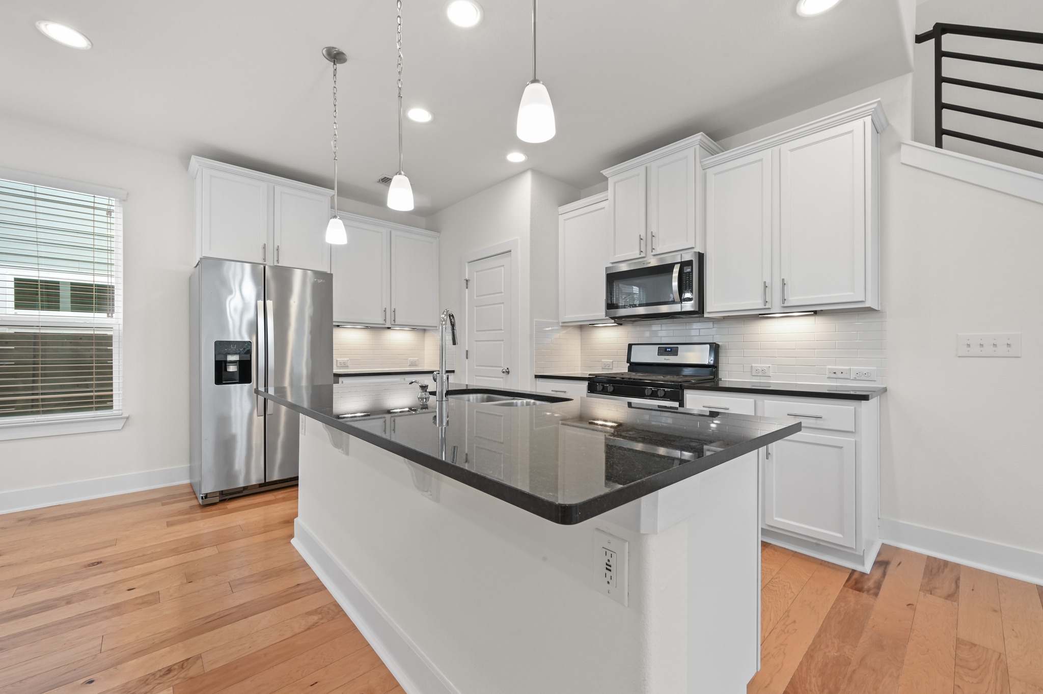 2204 Theseus Pass Austin, TX 78741 - Photo 10 of 31 a kitchen with stainless steel appliances granite countertop a sink refrigerator and microwave