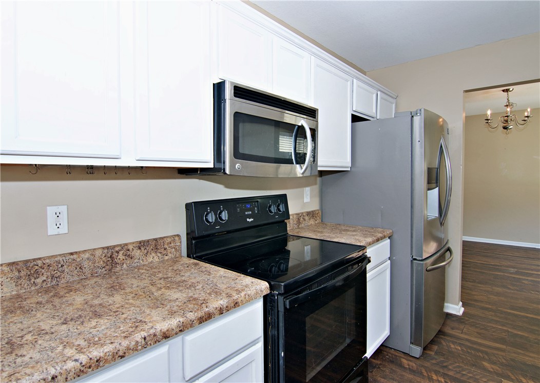 305 North Chestnut Street Seneca, SC 29678 - Photo 14 of 44 White cabinetry, an over-the-range microwave, and stainless steel appliances furnish this functional kitchen space.