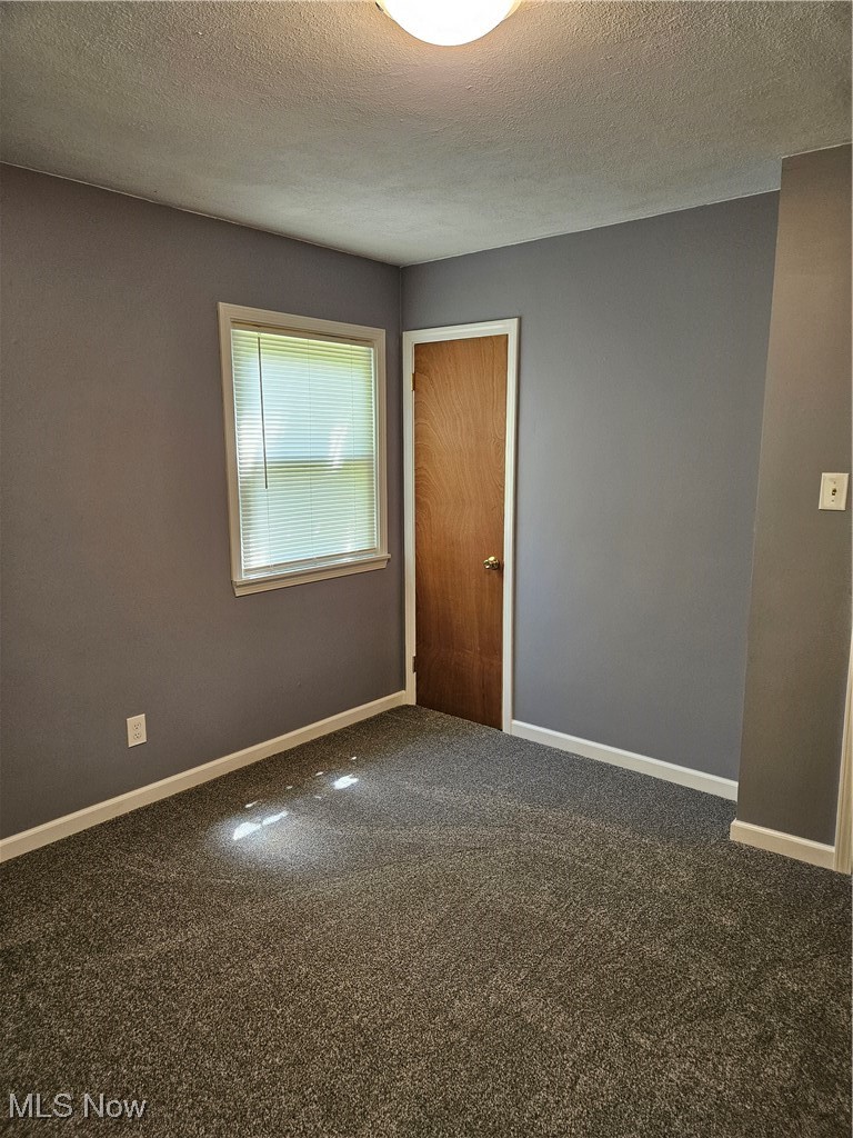 1895 Sandgate Road Madison, OH 44057 - Photo 15 of 16 Carpeted spare room featuring baseboards and a textured ceiling