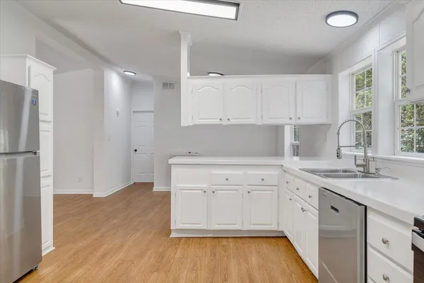 a kitchen with a sink cabinets stainless steel appliances and a window
