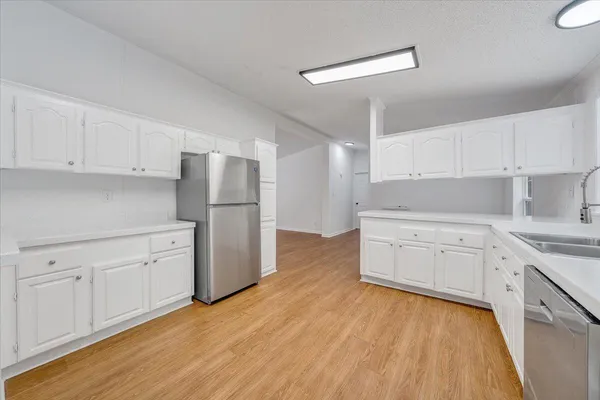 a kitchen with granite countertop white cabinets and white appliances