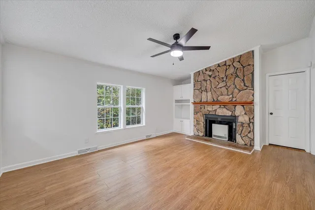 a view of an empty room with a fireplace and a window