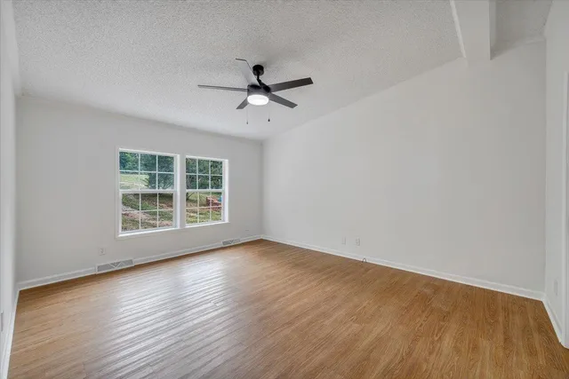 a view of a livingroom with wooden floor and a ceiling fan