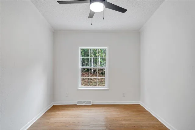 a view of empty room with wooden floor