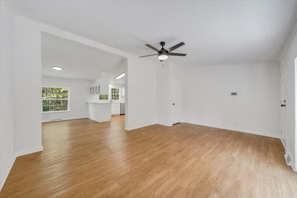 a view of empty room with wooden floor and window