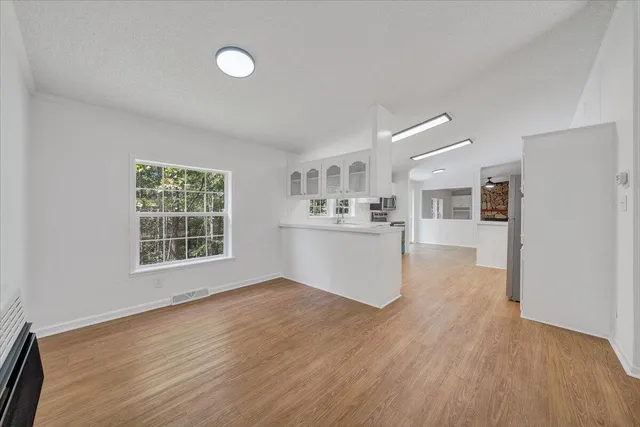 a view of a kitchen with wooden floor and a window