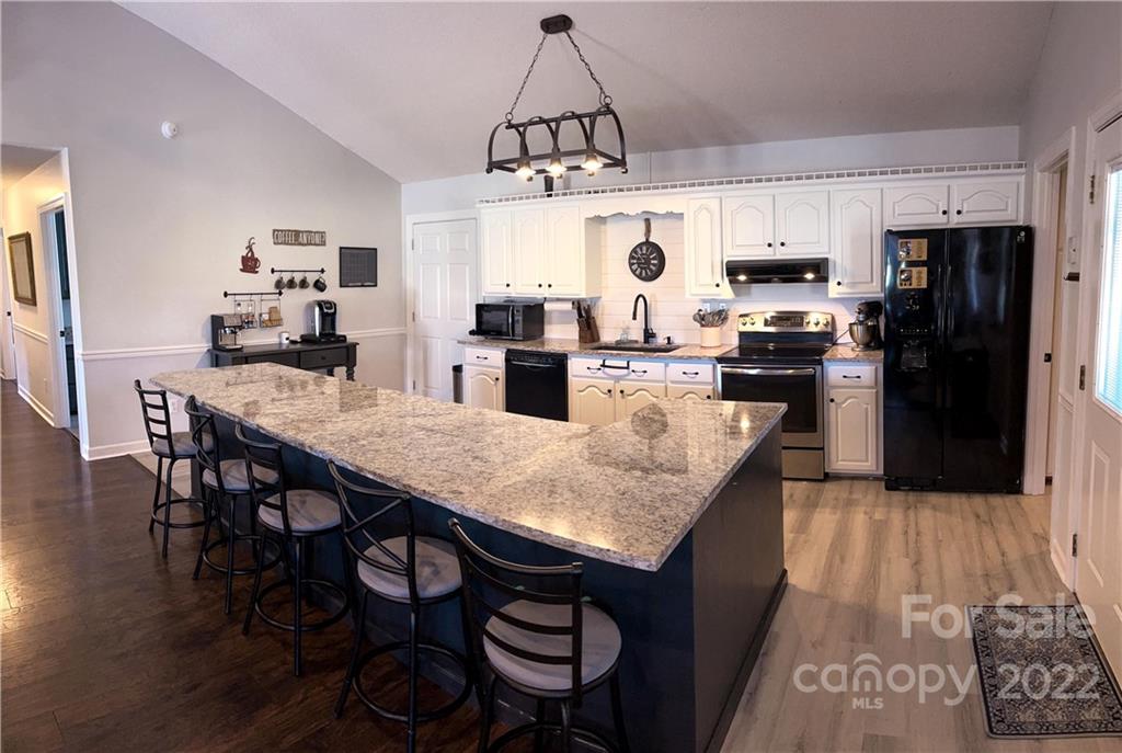 270 Tom Laney Road Lancaster, SC 29720 - Photo 10 of 28 a kitchen with kitchen island granite countertop a table chairs microwave and refrigerator