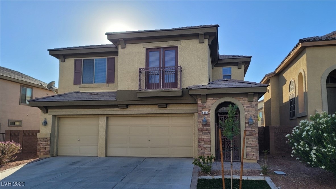 View of front of property featuring stone siding, an attached garage, stucco siding, and driveway