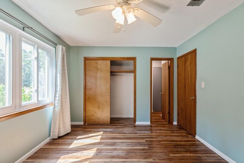 1086 County Highway 183 North DeFuniak Springs, FL 32433 - Photo 16 of 39 a view of a livingroom with wooden floor and a ceiling fan