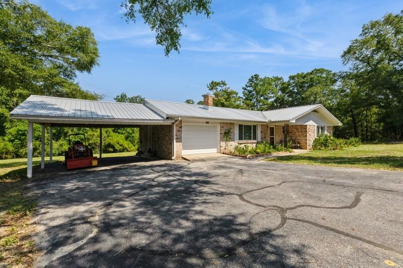 1086 County Highway 183 North DeFuniak Springs, FL 32433 - Photo 2 of 39 a front view of a house with a yard and garage