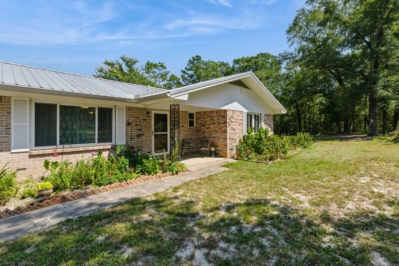 1086 County Highway 183 North DeFuniak Springs, FL 32433 - Photo 4 of 39 a front view of a house with a garden
