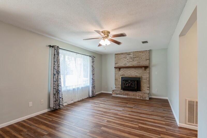 1086 County Highway 183 North DeFuniak Springs, FL 32433 - Photo 6 of 39 wooden floor fireplace and windows in an empty room