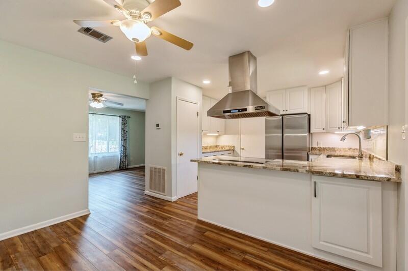 1086 County Highway 183 North DeFuniak Springs, FL 32433 - Photo 10 of 39 a kitchen with stainless steel appliances granite countertop a sink cabinets and wooden floor