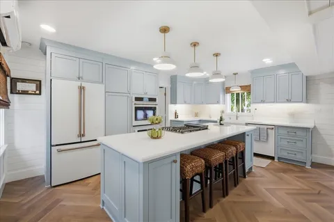 a kitchen with white cabinets and stainless steel appliances