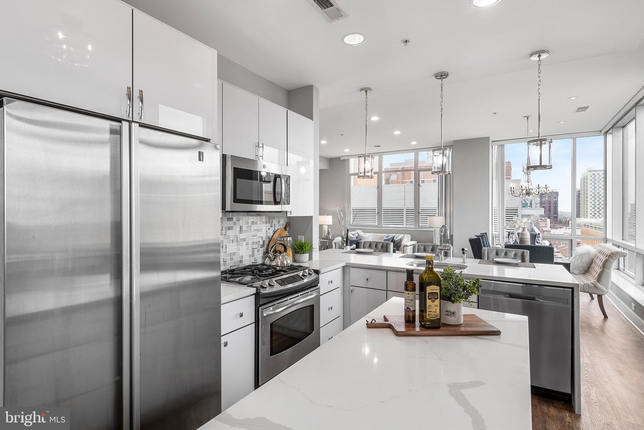 1101 Locust Street, Unit 8B Philadelphia, PA 19107 - Photo 11 of 36 a kitchen with refrigerator a stove and a sink with cabinets