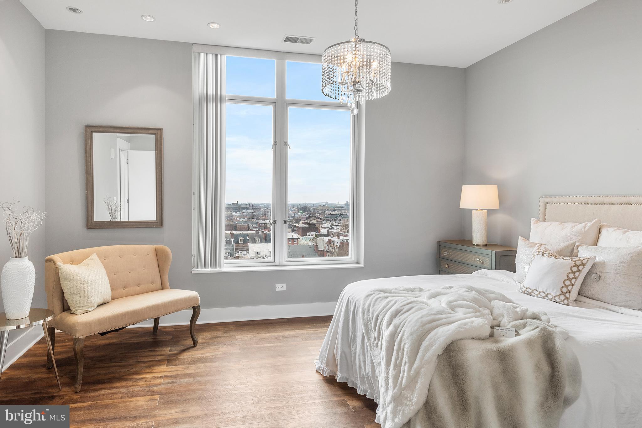 1101 Locust Street, Unit 8B Philadelphia, PA 19107 - Photo 19 of 36 a spacious bedroom with a bed and a chandelier