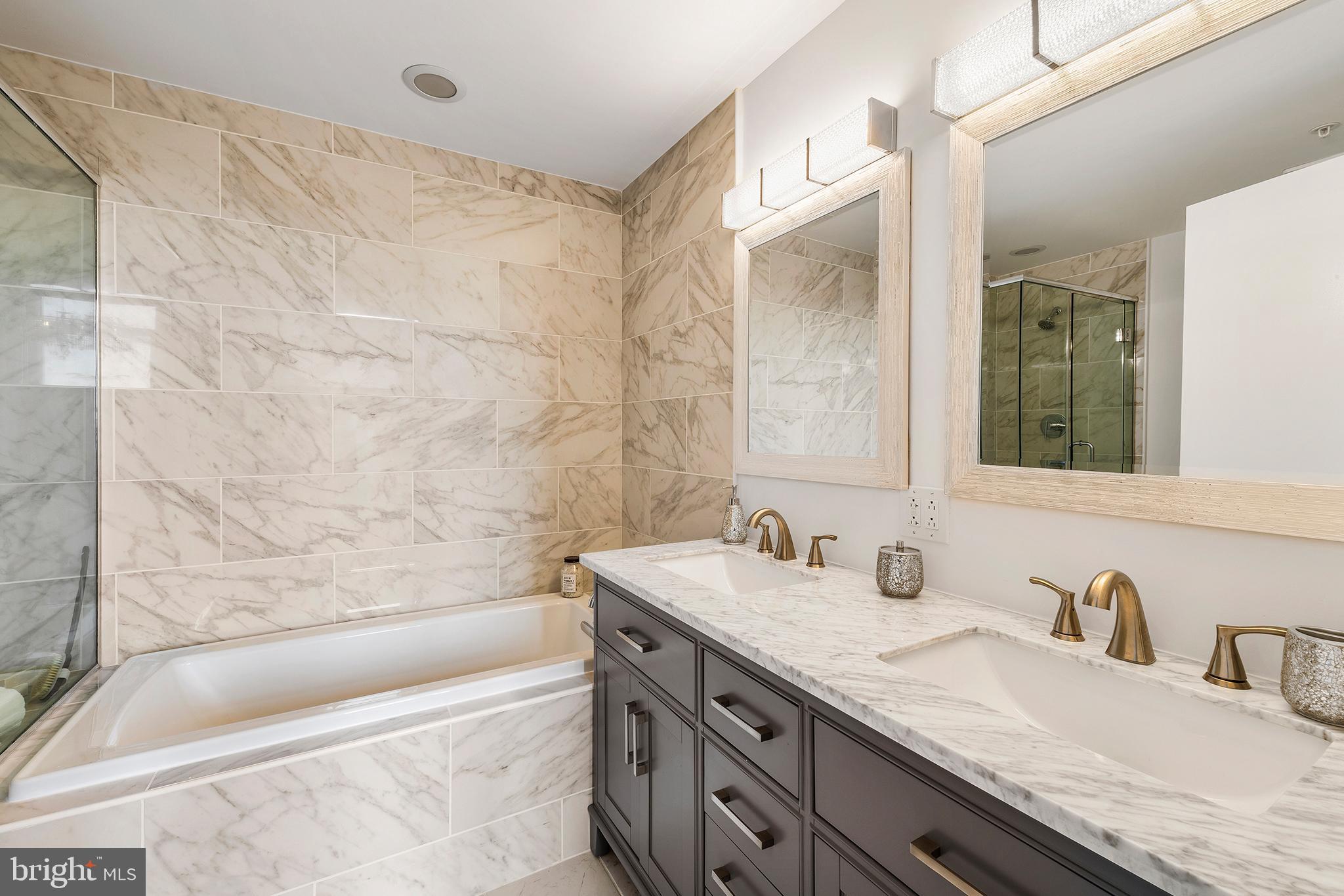 1101 Locust Street, Unit 8B Philadelphia, PA 19107 - Photo 20 of 36 a bathroom with a granite countertop bathtub sink vanity and mirror