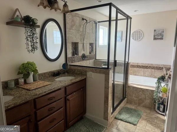 a bathroom with a granite countertop sink a mirror and shower