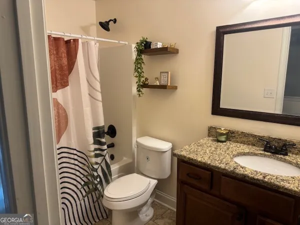 a bathroom with a granite countertop sink toilet and a mirror