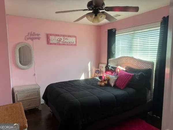 a bedroom with a bed dresser and a window