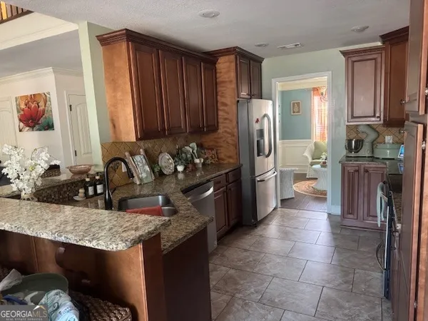 a kitchen with stainless steel appliances granite countertop a sink stove and refrigerator