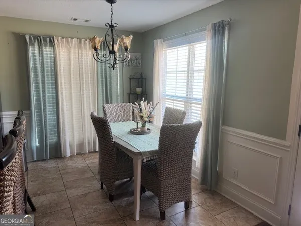a dining room with furniture a chandelier and window