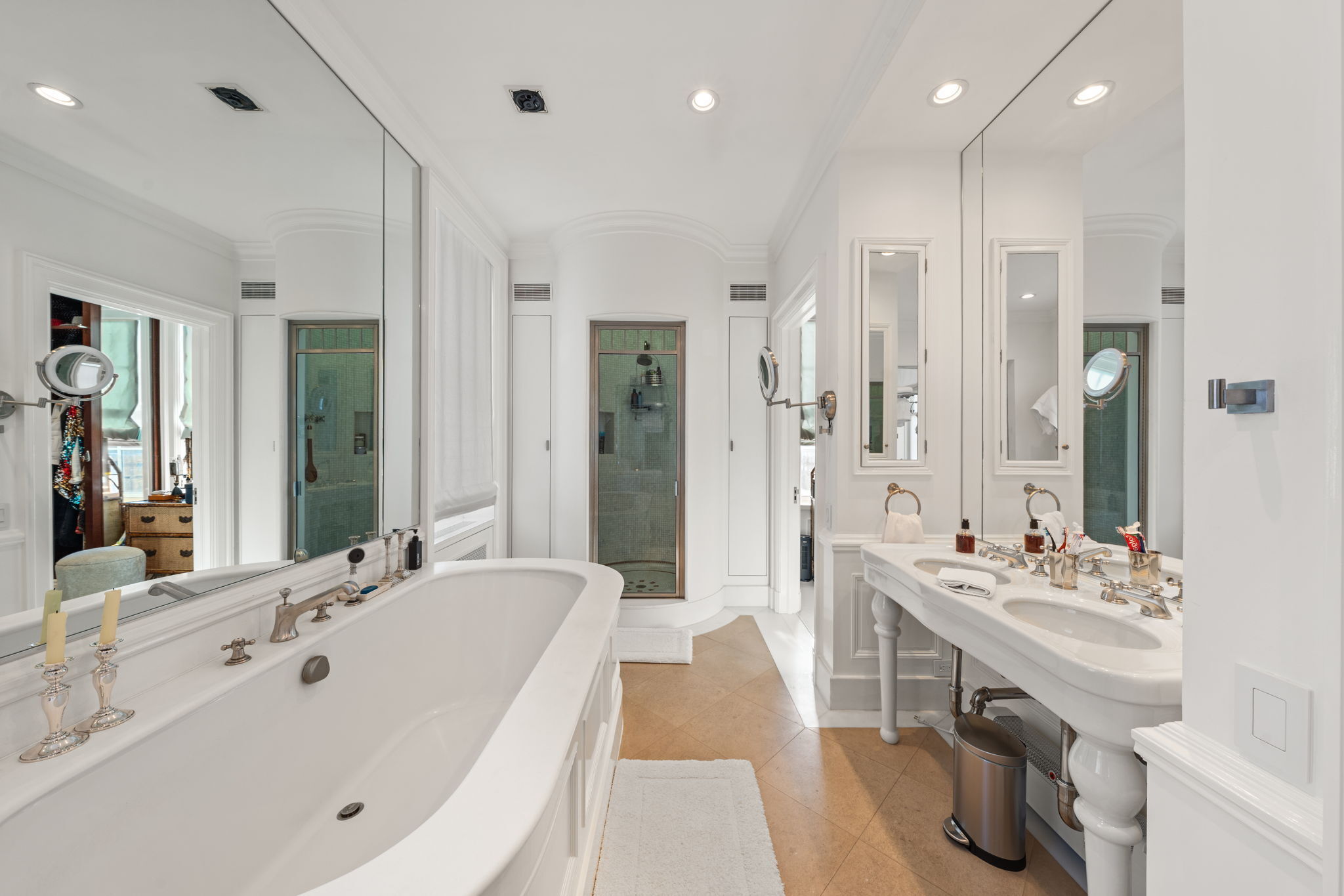 32 East 64th Street, Unit 9W Manhattan, NY 10065 - Photo 11 of 16 a bathroom with a double vanity sink a mirror and shower