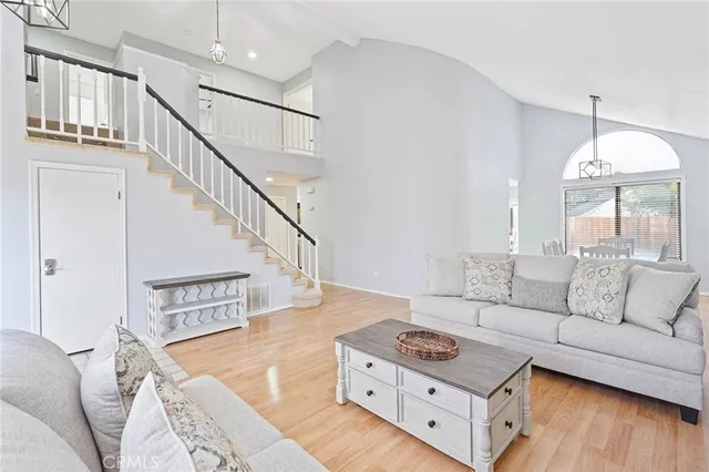 a living room with couches and a large mirror with wooden floor