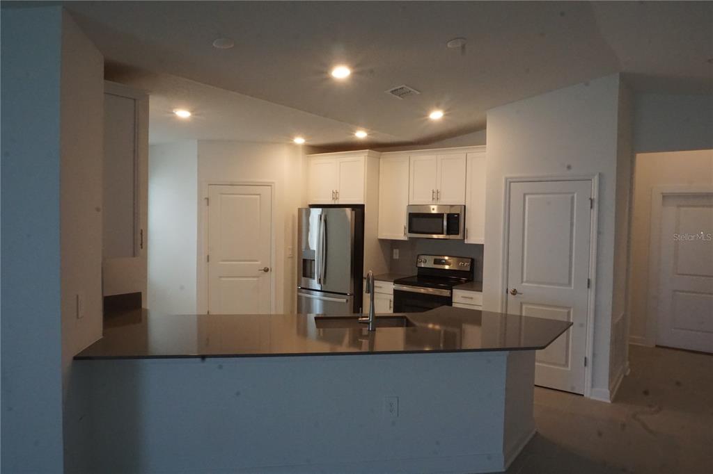 5704 Stephens Road St. Cloud, FL 34771 - Photo 5 of 12 a view of a refrigerator in kitchen and living room