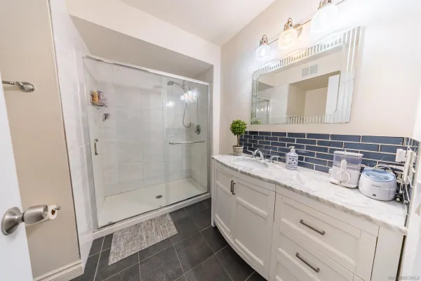 a bathroom with a shower sink and mirror