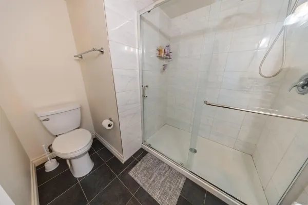 a bathroom with a granite countertop toilet and a shower
