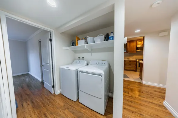 a utility room with wooden floor washer and dryer